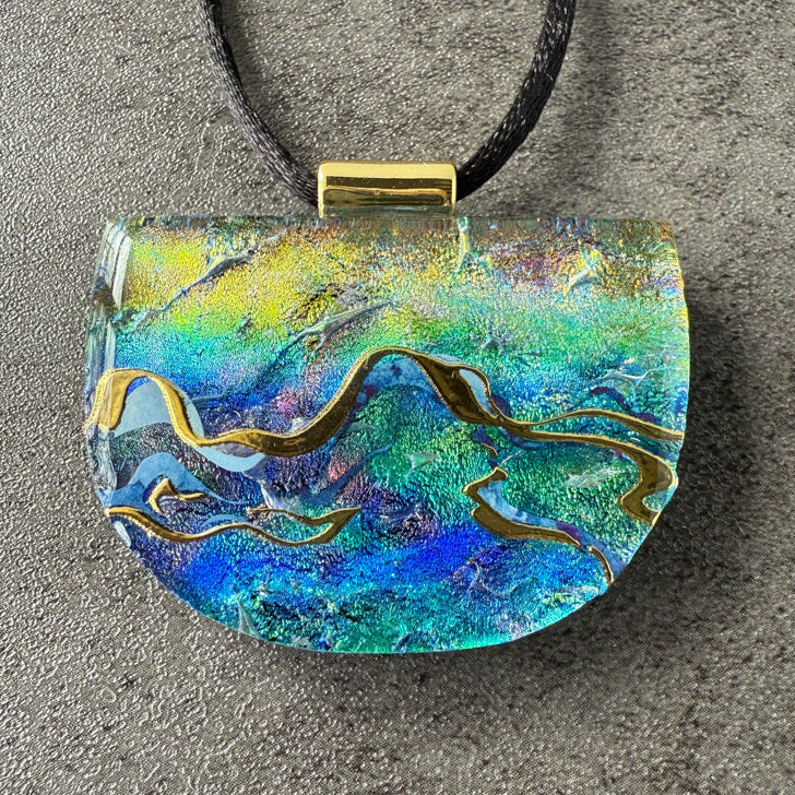 Colorful pendant with abstract design on a gray surface
