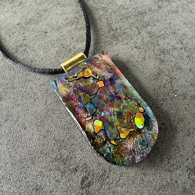 Colorful pendant with abstract designs on a textured surface