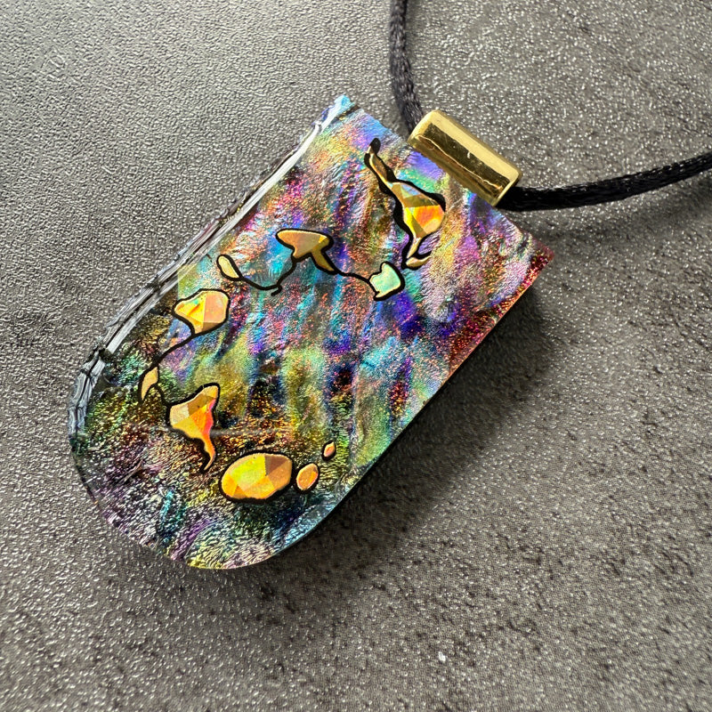 Colorful pendant with star designs on a gray surface