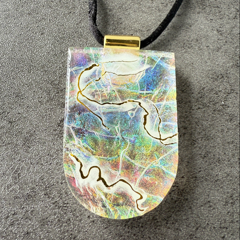 Marbled pendant necklace on a textured gray surface