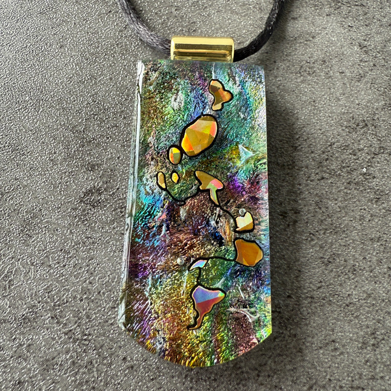 Multicolored pendant with a gold accent on a gray surface