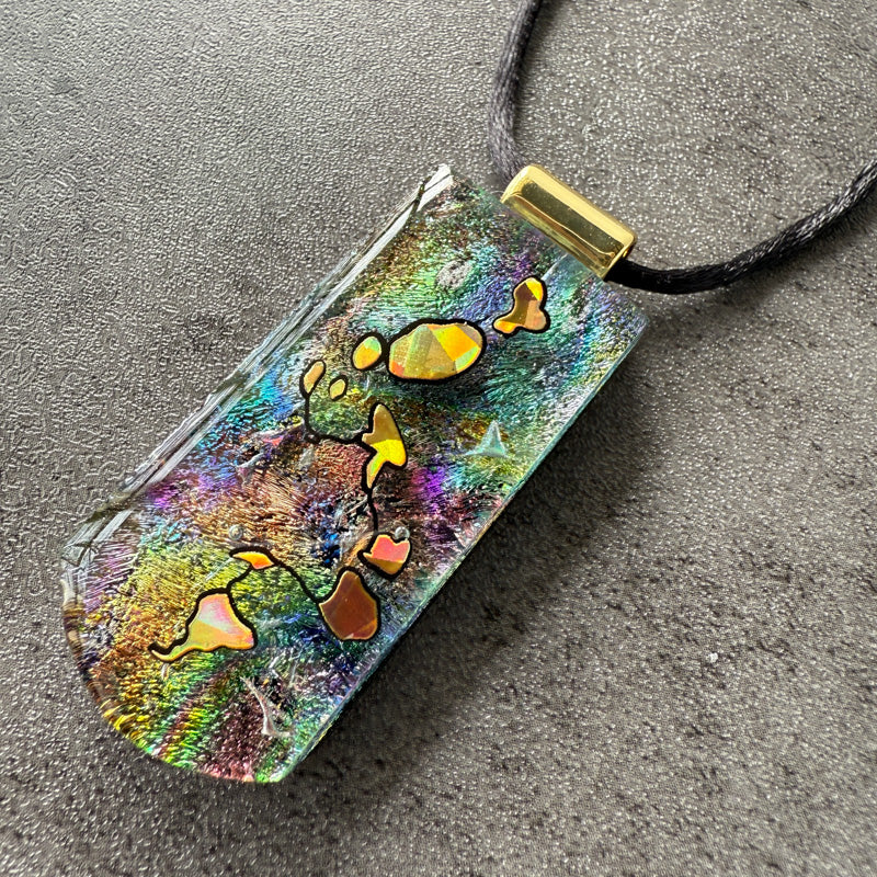 Colorful pendant with abstract designs on a gray surface