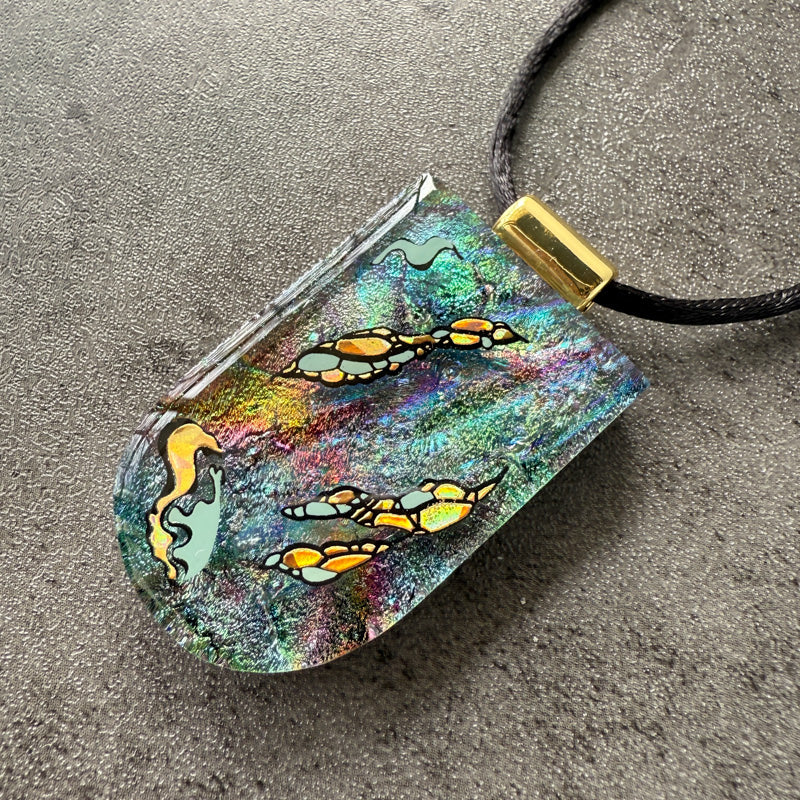 Colorful pendant with butterfly design on a gray surface