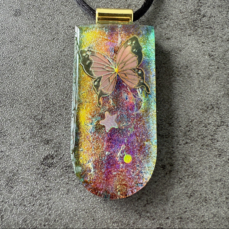 Colorful pendant with butterfly design on a textured surface