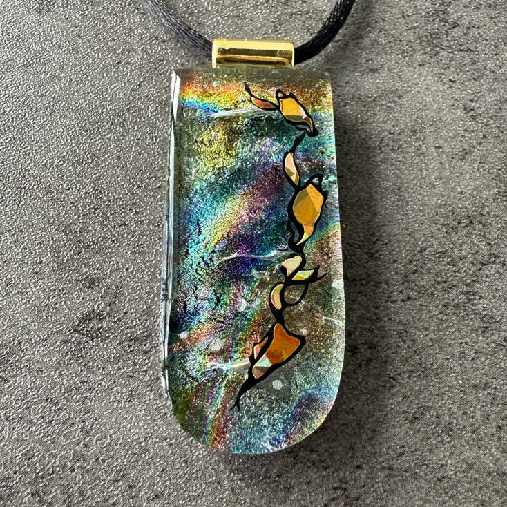 Colorful pendant with abstract design on a gray surface