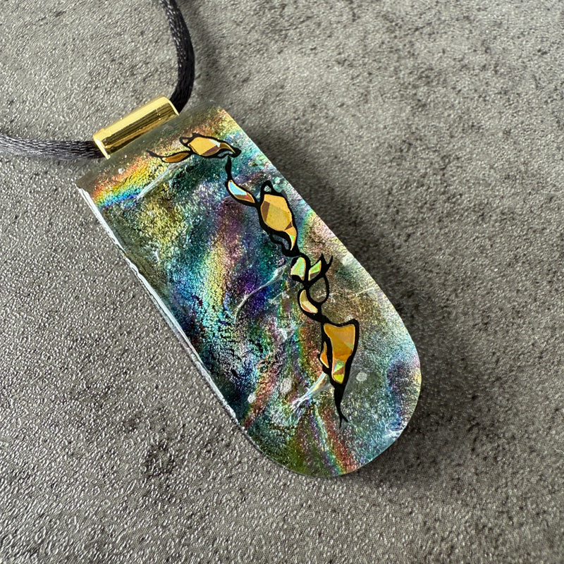 Colorful pendant with abstract design on a gray surface