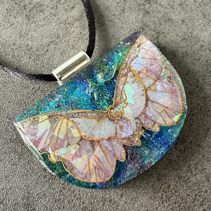 Butterfly-shaped pendant with glittery finish on a textured surface