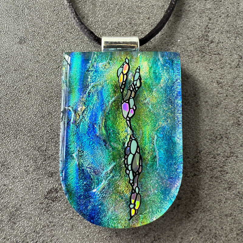 Colorful pendant with abstract design on a textured surface