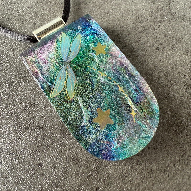 Decorative pendant with butterfly and star designs on a textured surface