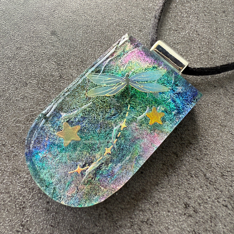 Iridescent pouch with fairy and star design on a gray surface