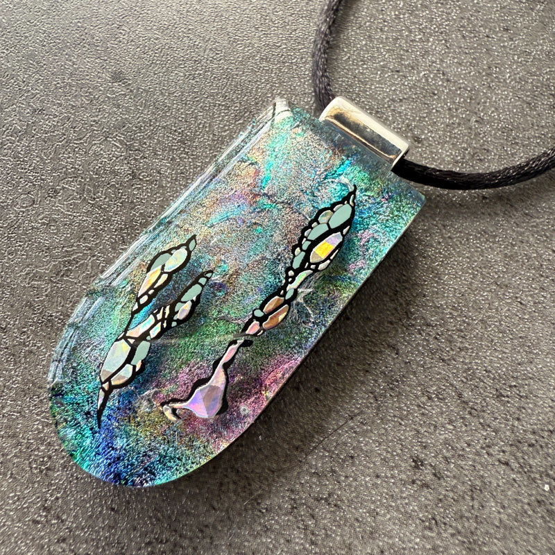 Colorful pendant with abstract designs on a gray surface