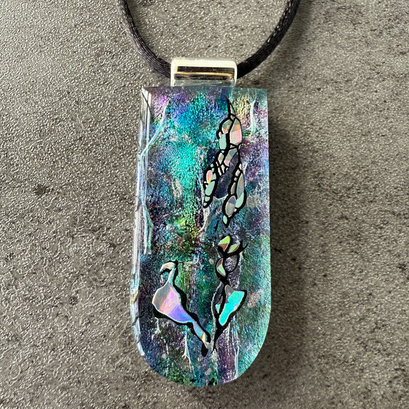 Colorful pendant with abstract designs on a textured surface