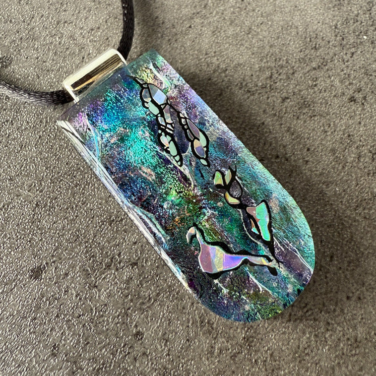 Colorful pendant with abstract design on a textured surface