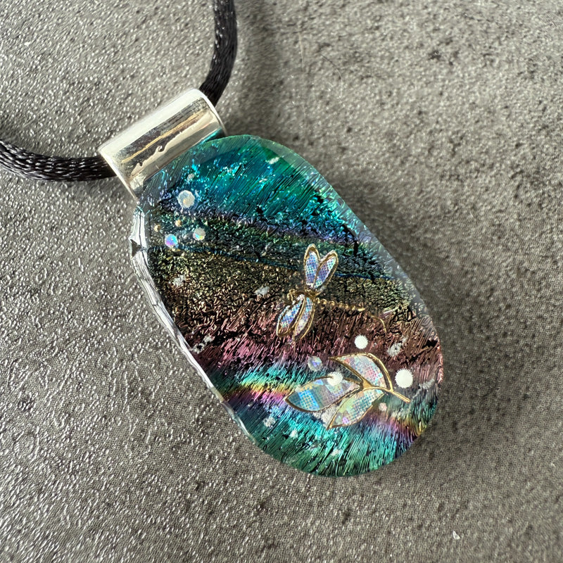 Colorful pendant with butterfly designs on a textured surface