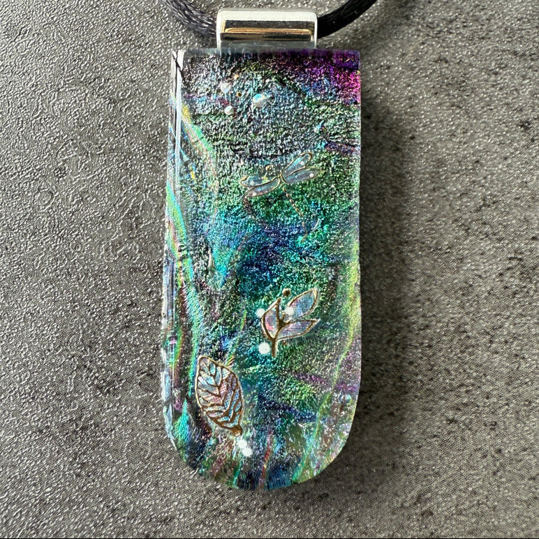 Colorful pendant with leaf design on a gray surface