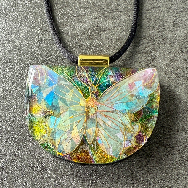 Butterfly-shaped pendant on a gray surface
