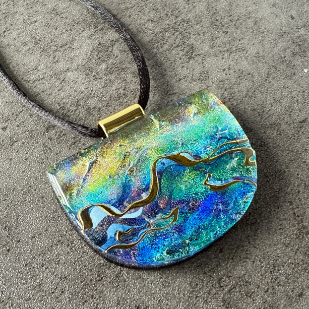 Colorful pendant necklace on a textured surface