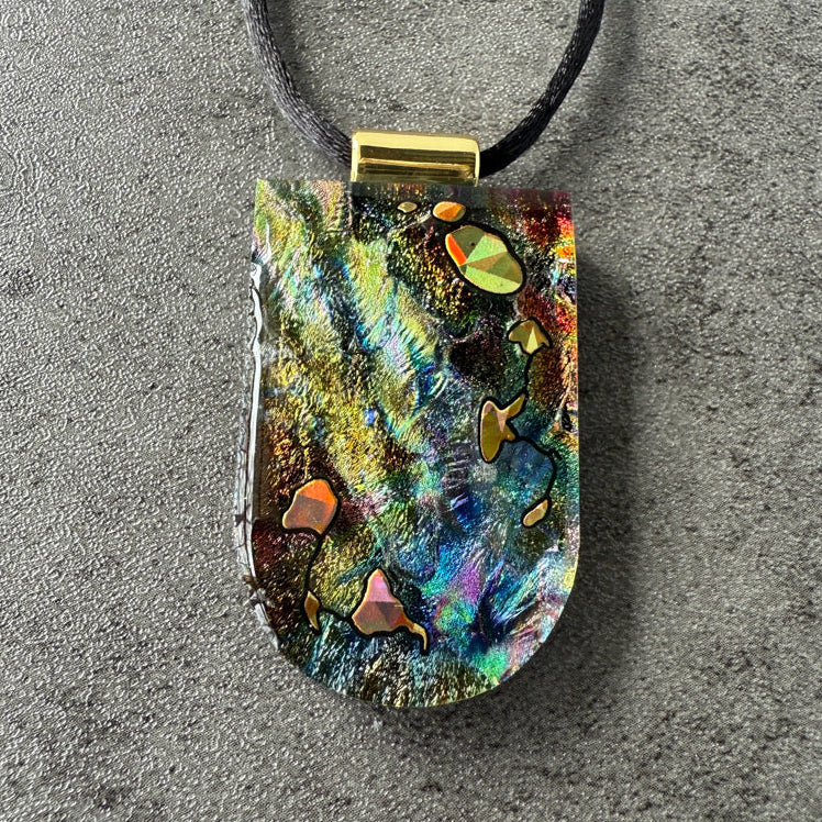 Multicolored pendant on a gray surface