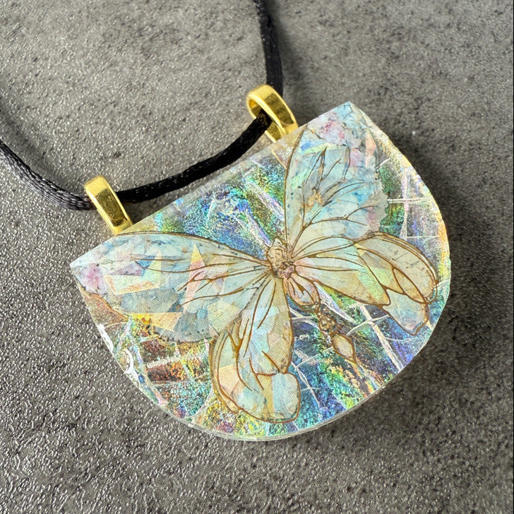 Butterfly pendant with iridescent finish on a textured surface