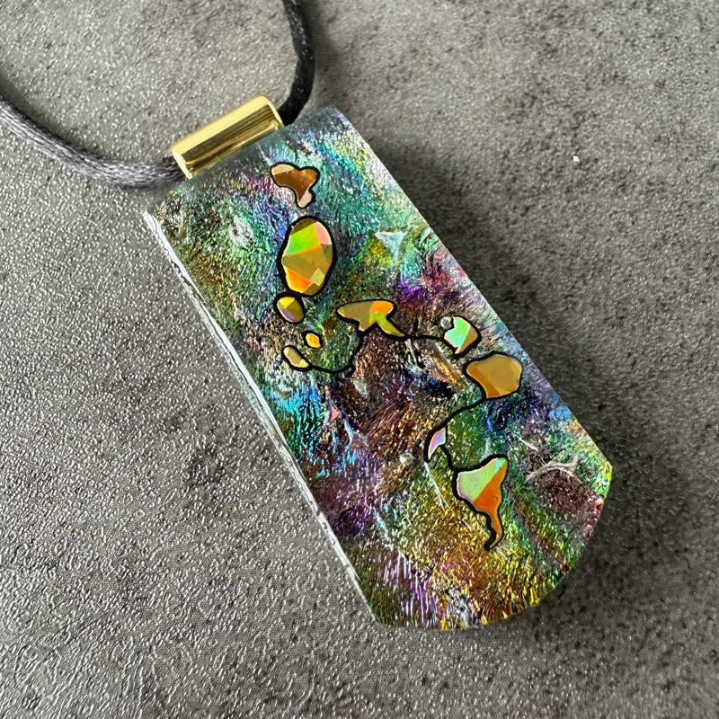 Colorful pendant with abstract design on a textured surface