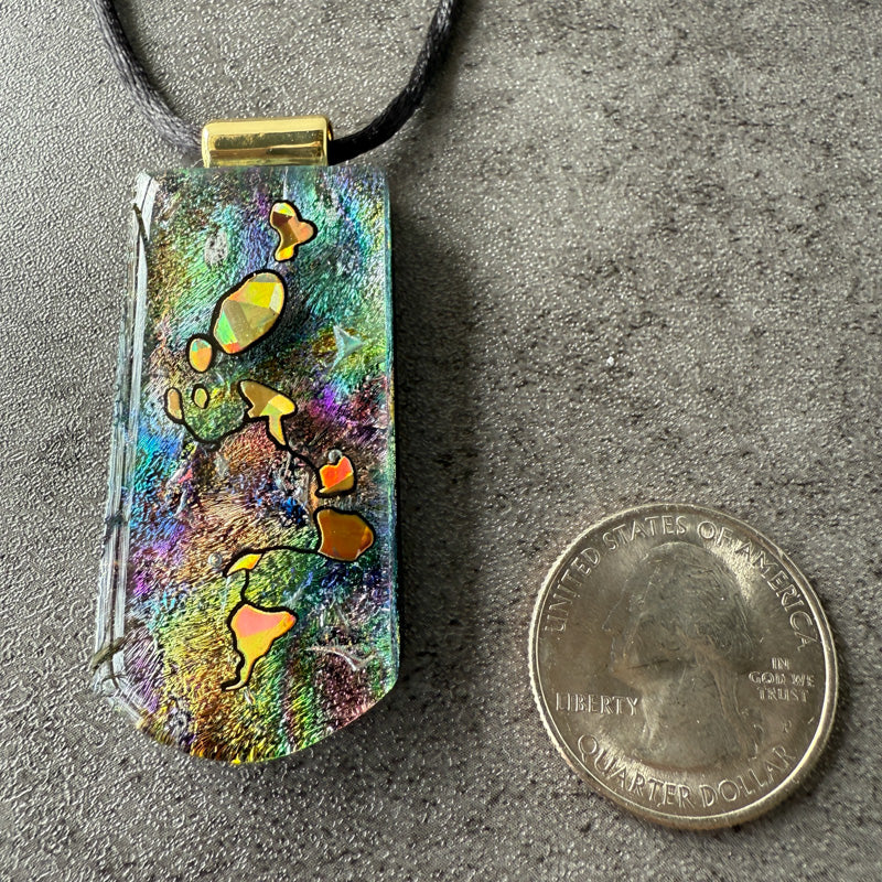 Colorful pendant with a quarter for scale on a gray surface