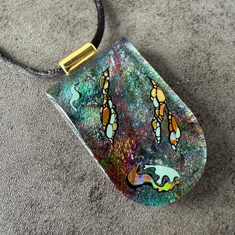 Colorful pendant with butterfly design on a textured surface