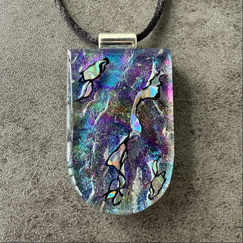 Colorful pendant with abstract design on a gray surface