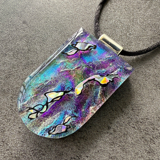 Colorful pendant with abstract design on a gray surface