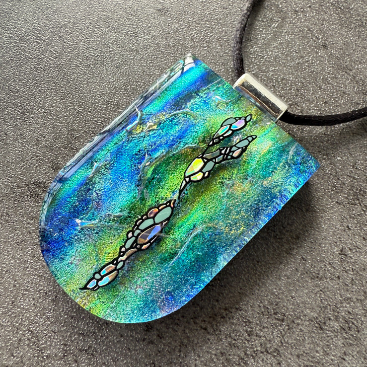 Colorful pendant with abstract design on a gray surface