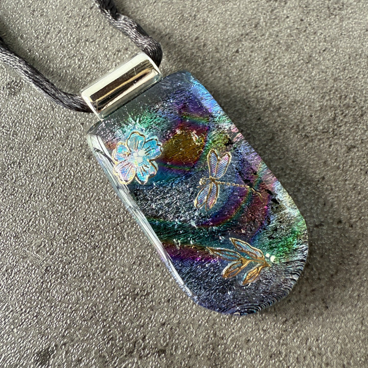Colorful pendant with floral designs on a textured surface