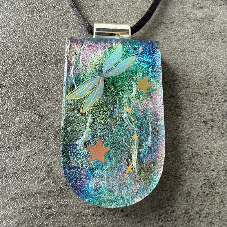 Decorative pendant with fairy and star designs on a textured surface