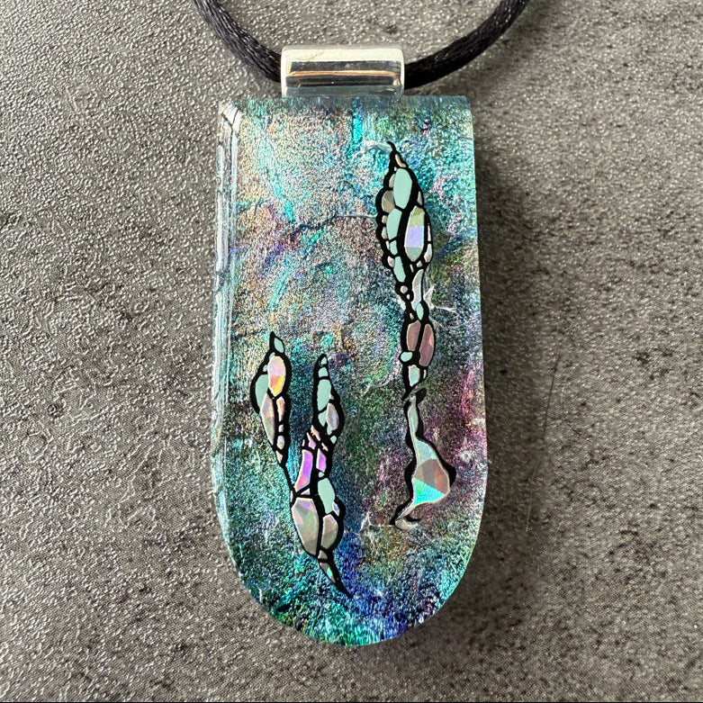 Multicolored pendant with abstract designs on a textured surface
