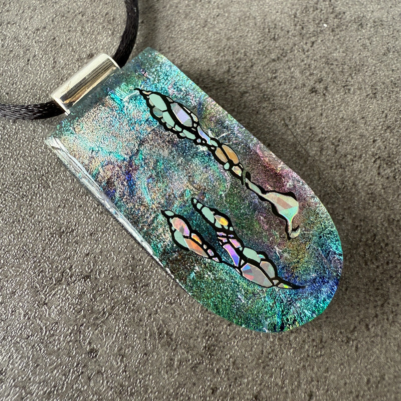 Colorful pendant with butterfly design on a textured surface