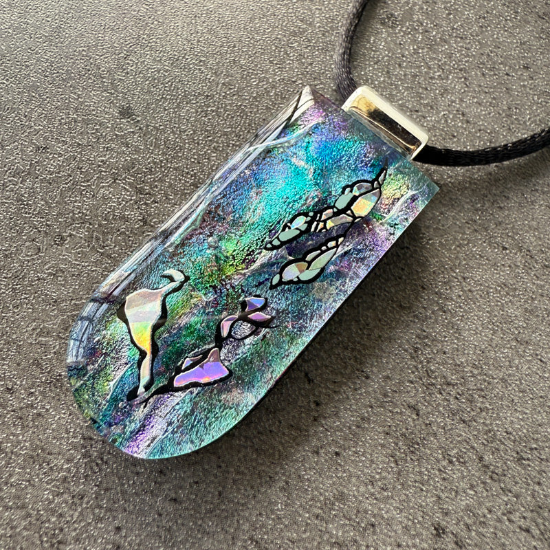 Colorful pendant with abstract designs on a textured surface