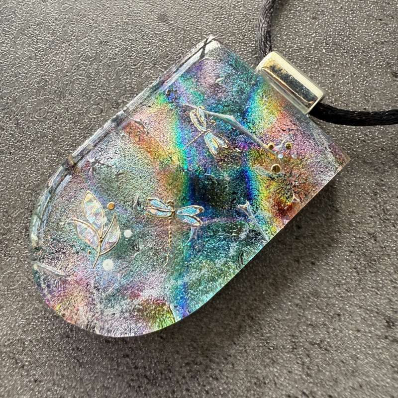 Multicolored pendant with leaf designs on a gray surface